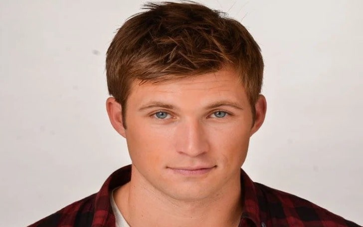 Justin Deeley in a white shirt and red-black check shirt.